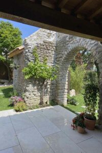 Cour en pierre naturelle avec arches et plantations méditerranéennes