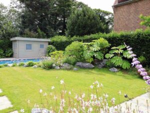 Jardin avec pelouse, cabanon et massifs de fleurs blanches