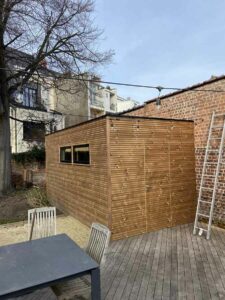 Abri de jardin moderne en bois avec terrasse attenante et mobilier d’extérieur