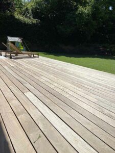 Terrasse spacieuse en bois exotique avec coin détente et jeux pour enfants