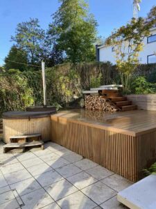 Terrasse en bois naturel avec bain nordique, escalier et espace de rangement