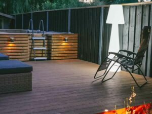 Terrasse extérieure en bois avec piscine hors-sol et éclairage LED chaleureux