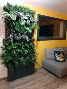 Mur végétal intérieur dans un salon moderne aux tons jaunes et gris
