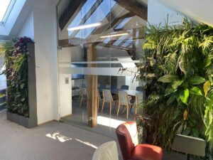 Deux murs végétaux encadrant une salle de réunion vitrée