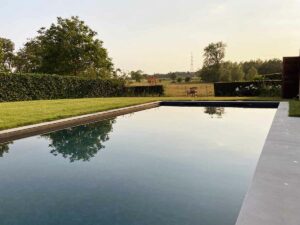 Piscine à débordement donnant sur la campagne au coucher du soleil