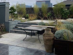 Terrasse contemporaine avec mobilier en acier et végétation ornementale