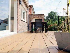 Terrasse en bois clair avec mobilier extérieur et façade en briques