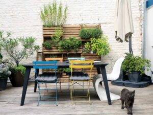 Terrasse urbaine avec mur de plantes aromatiques et mobilier coloré