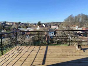 Terrasse panoramique en bois avec garde-corps métallique et vue sur la ville