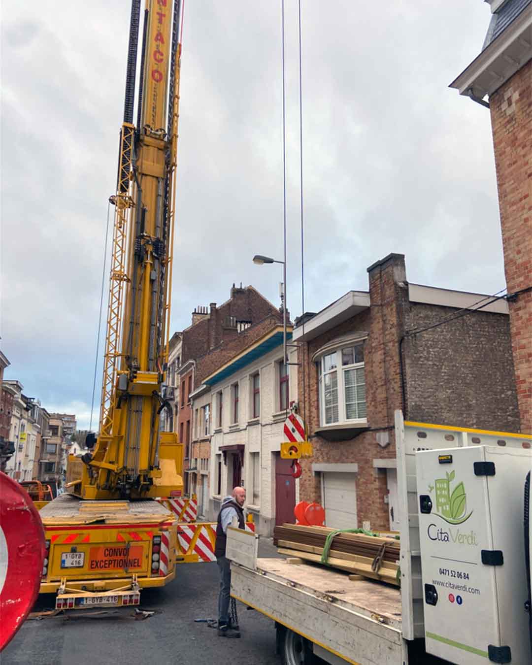 Camion Cita Verdi et grue de levage lors d’une livraison de matériaux en centre-ville