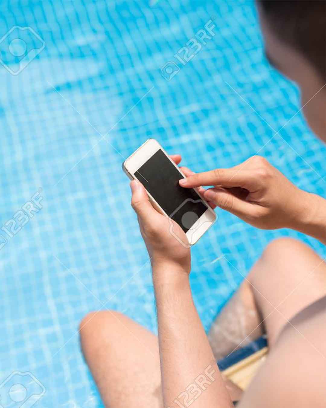 Personne contrôlant une piscine connectée depuis son smartphone au bord de l’eau
