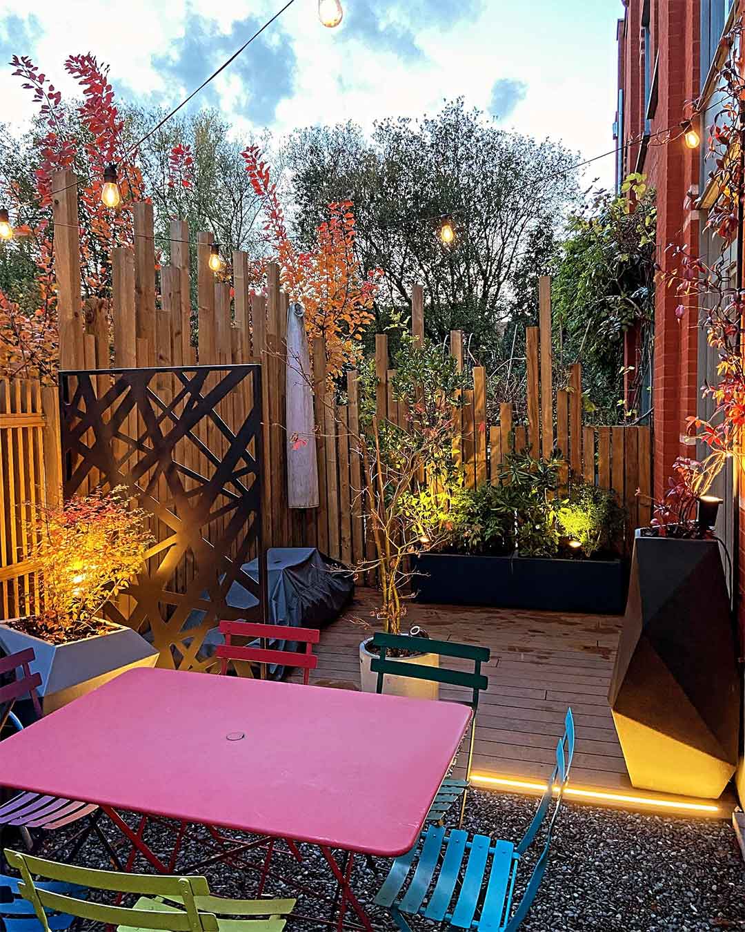 Terrasse urbaine décorée de mobilier coloré et de guirlandes lumineuses