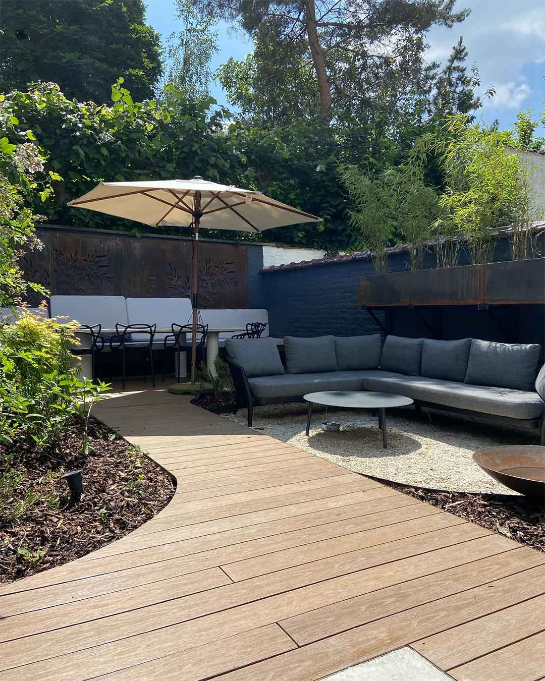 Terrasse paysagée avec salon d’extérieur et allée en bois